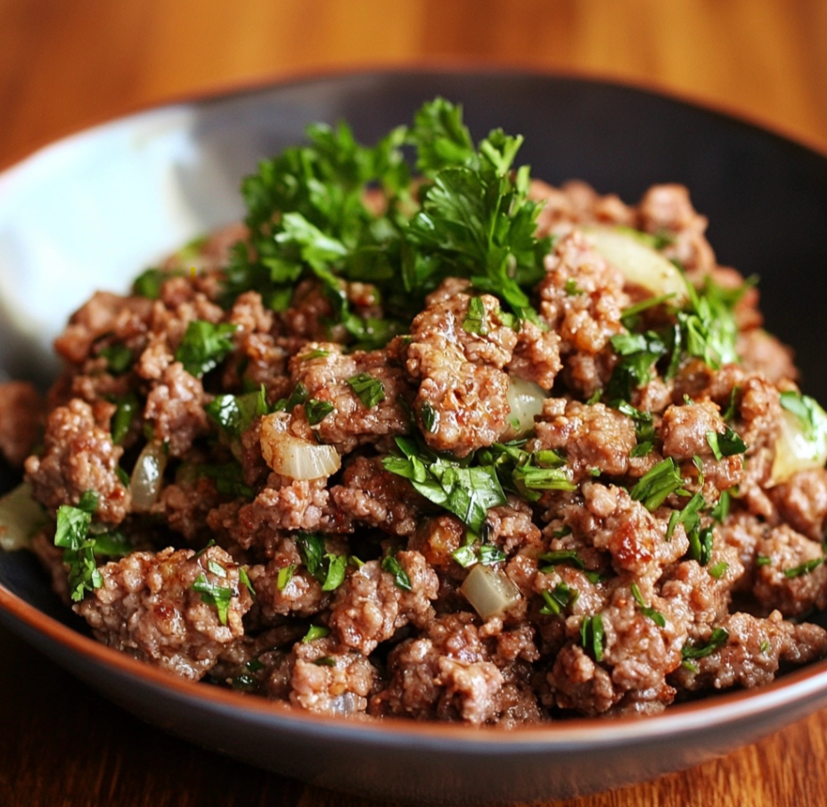 A plate of ground lamb patties served with couscous and a fresh cucumber salad.